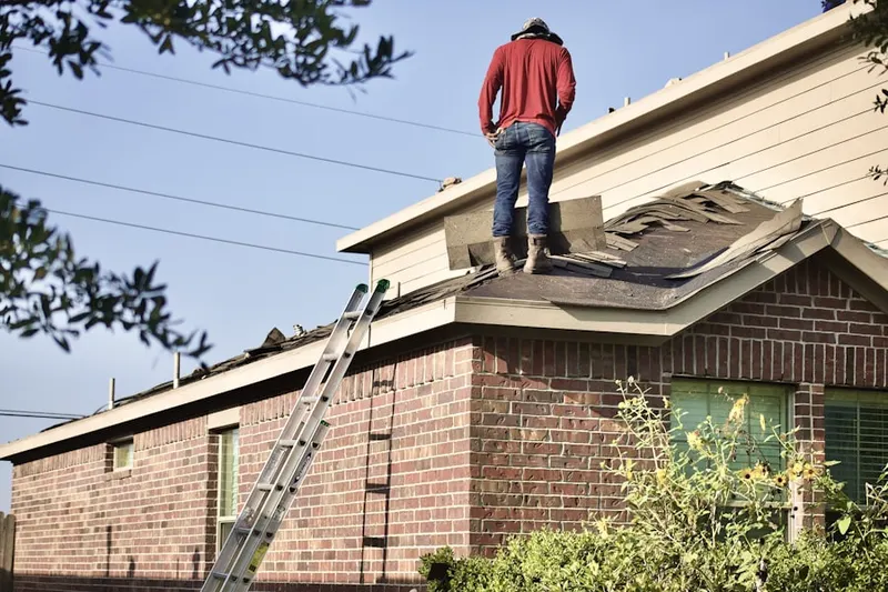 Professional roofer working on a residential roof in Byrd